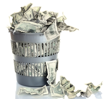 A photo of a wastebasket full of crumpled money to illustrate money wasted on poor SEO strategies