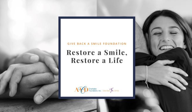 woman hugging her dentist with box in middle that says "Give Back a Smile Foundation, restore a smile, restore a life."