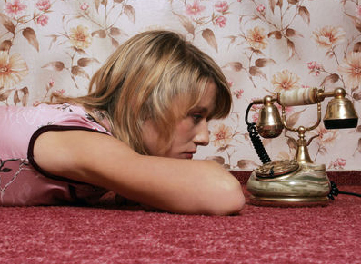 Woman waiting at old fashion phone for phone call.